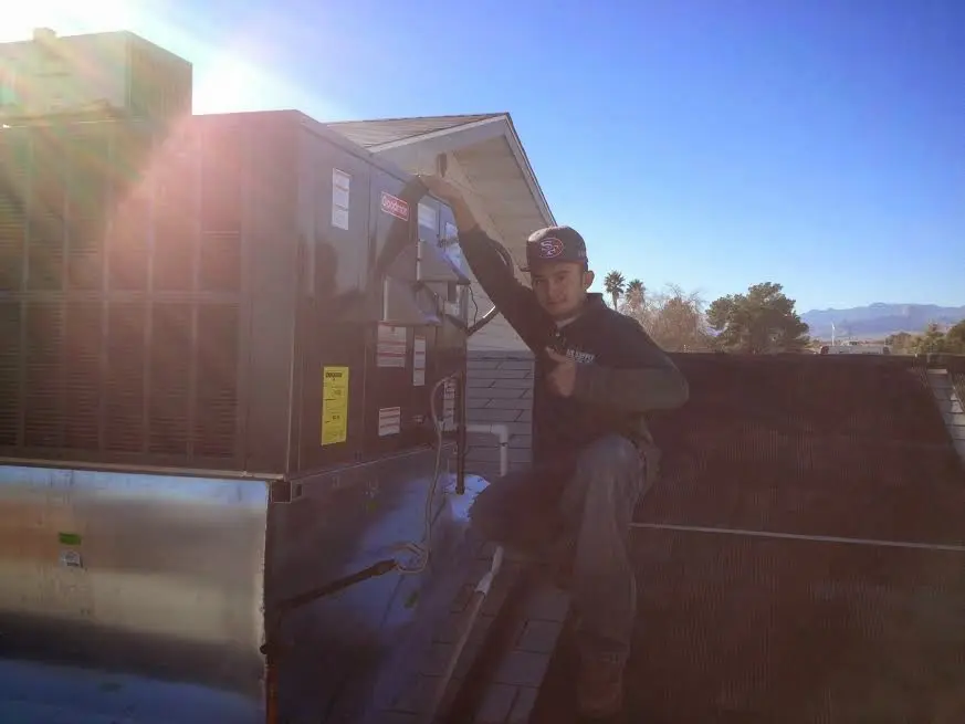 HVAC technician performing Boiler Repair on a rooftop unit in East Haddam